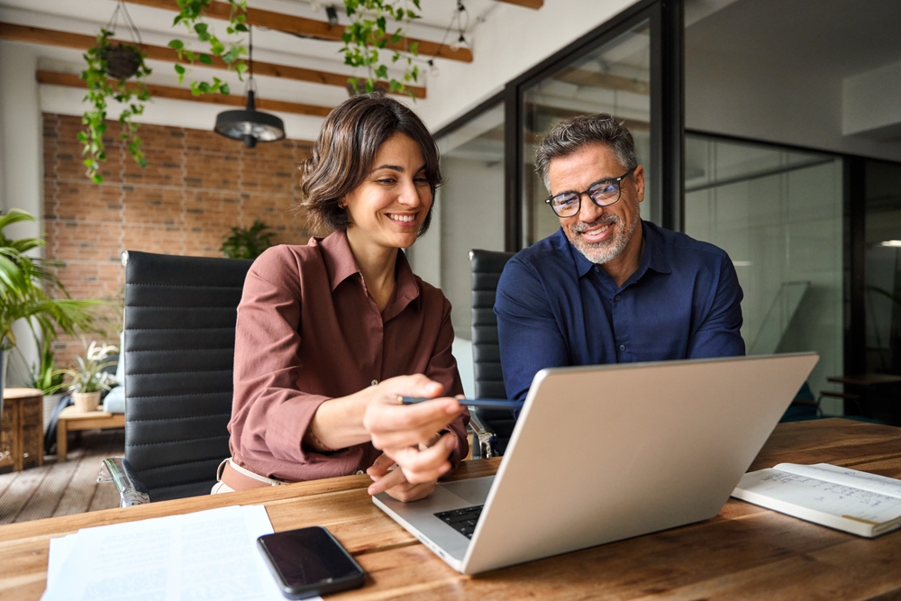 Business Team Of Two Executives Working Together Using Laptop 