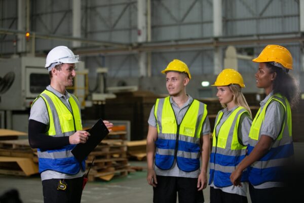 Group Of Diverse Industrial Workers In Safety Vests And Helmets